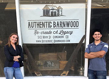 photo of authentic barnwood sign and owners